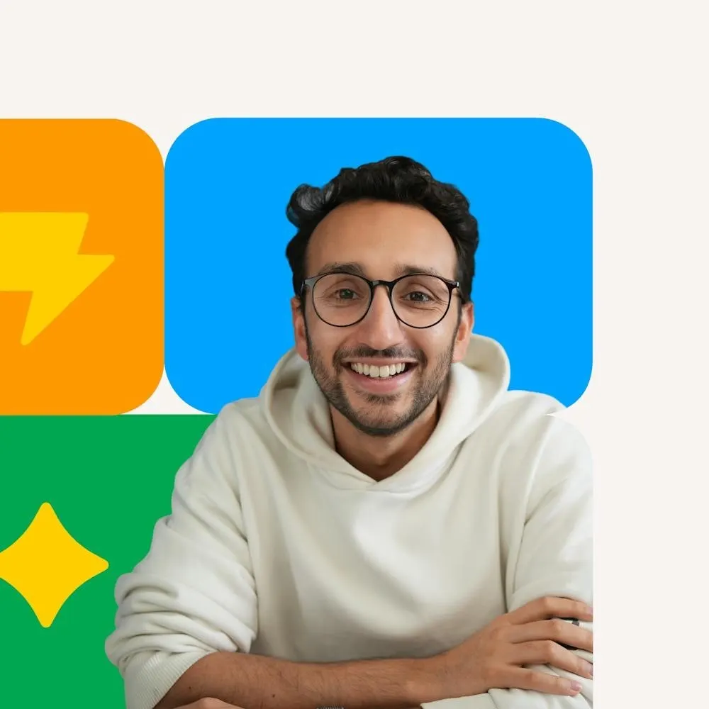 Ali in a cream hoodie in front of bright colored blocks