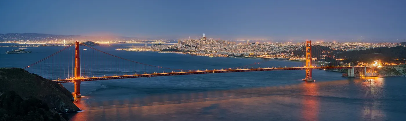 Golden Gate Bridge at dusk with city lights