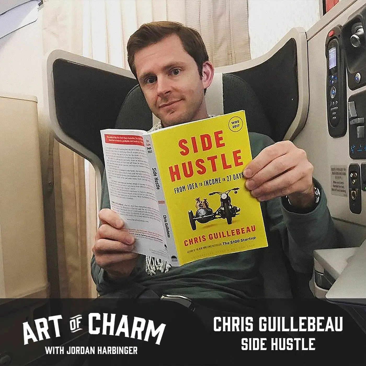 Guillebeau in premium airplane seat holding Side Hustle for Art of Charm