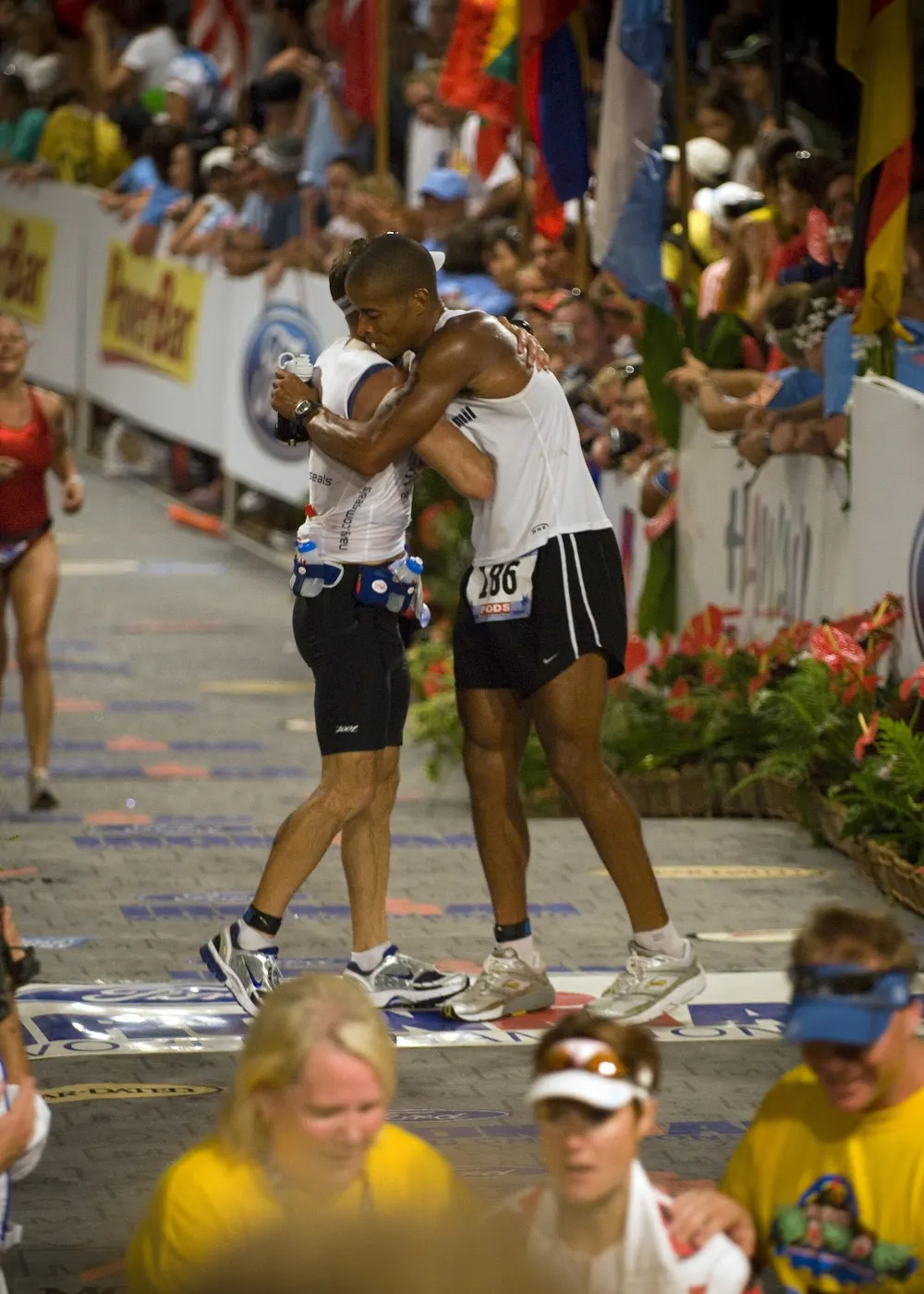 Goggins at the Ironman World Championship finish in Kona, hugging someone at the finish line
