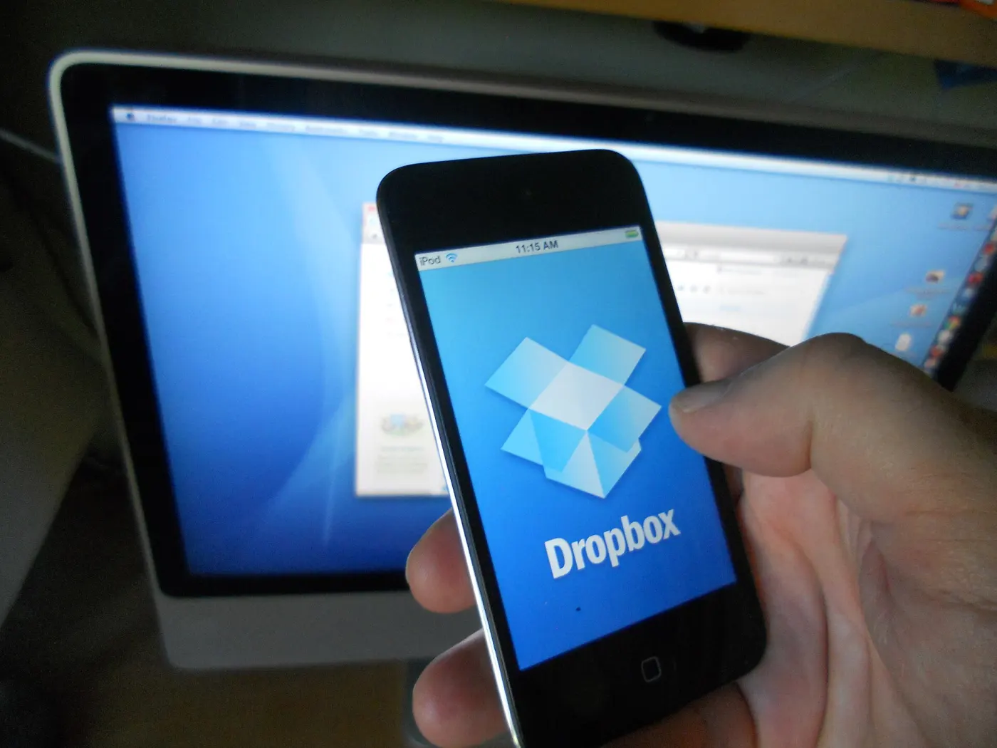 Early Dropbox app on a handheld device beside a Mac