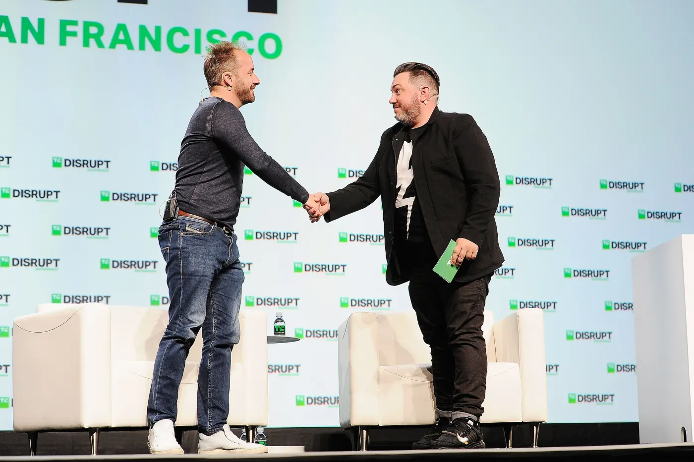 Houston shaking hands on TechCrunch Disrupt stage