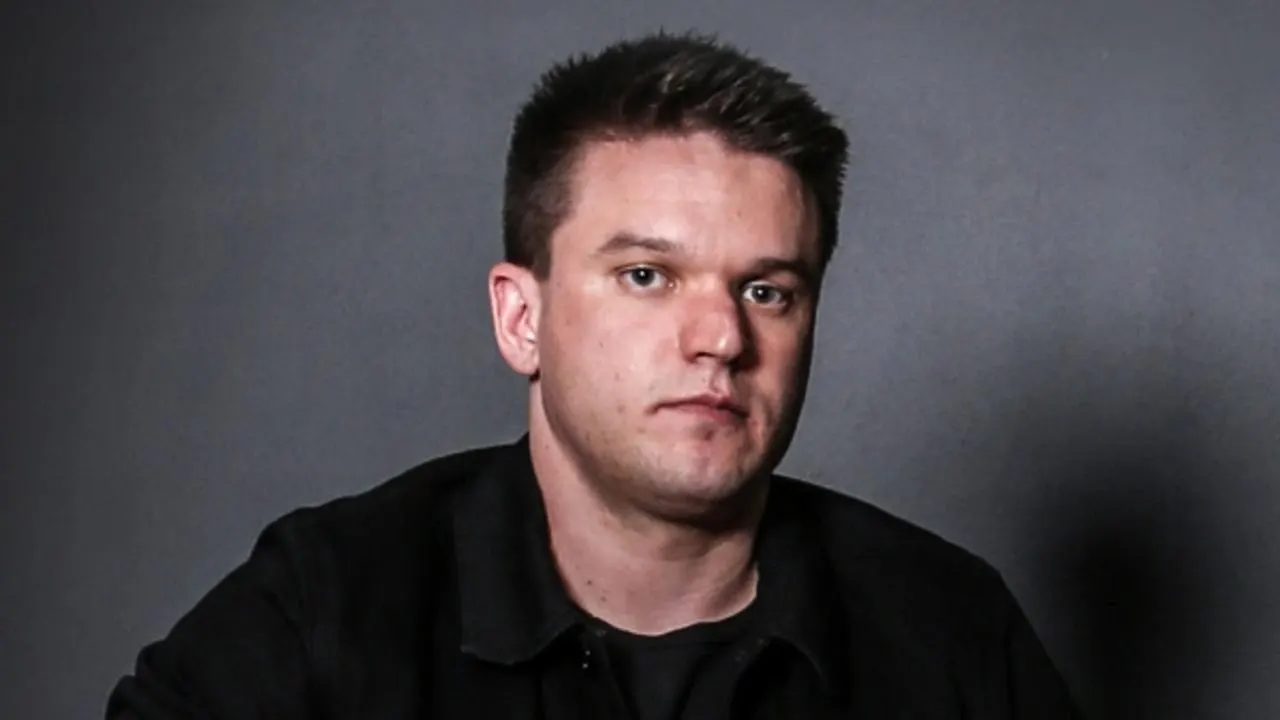 Serious studio portrait of Craven in dark jacket