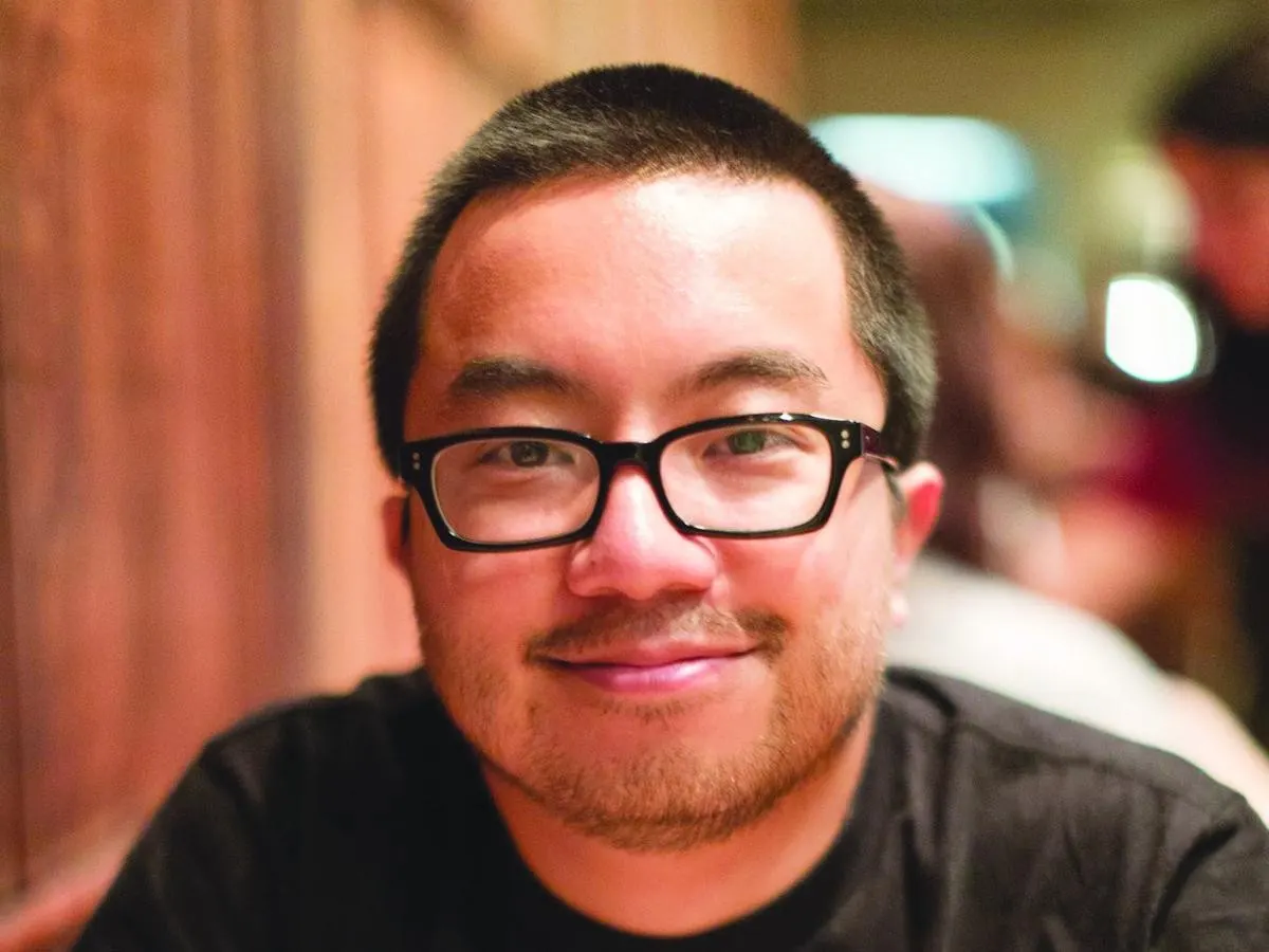 Warm indoor close portrait of Garry Tan in black tee