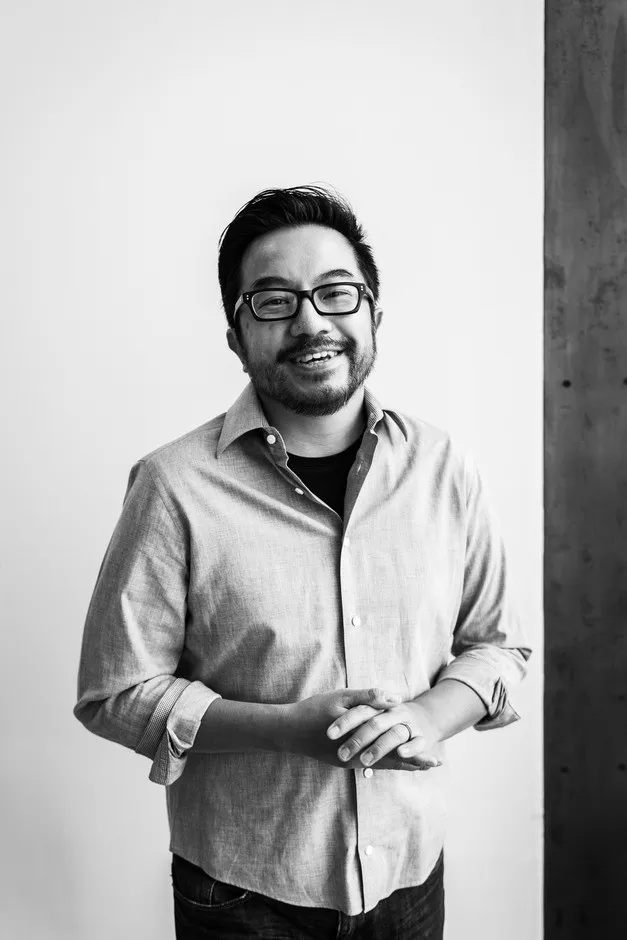 Black-and-white waist-up portrait of Garry Tan, glasses, beard, light shirt over dark tee