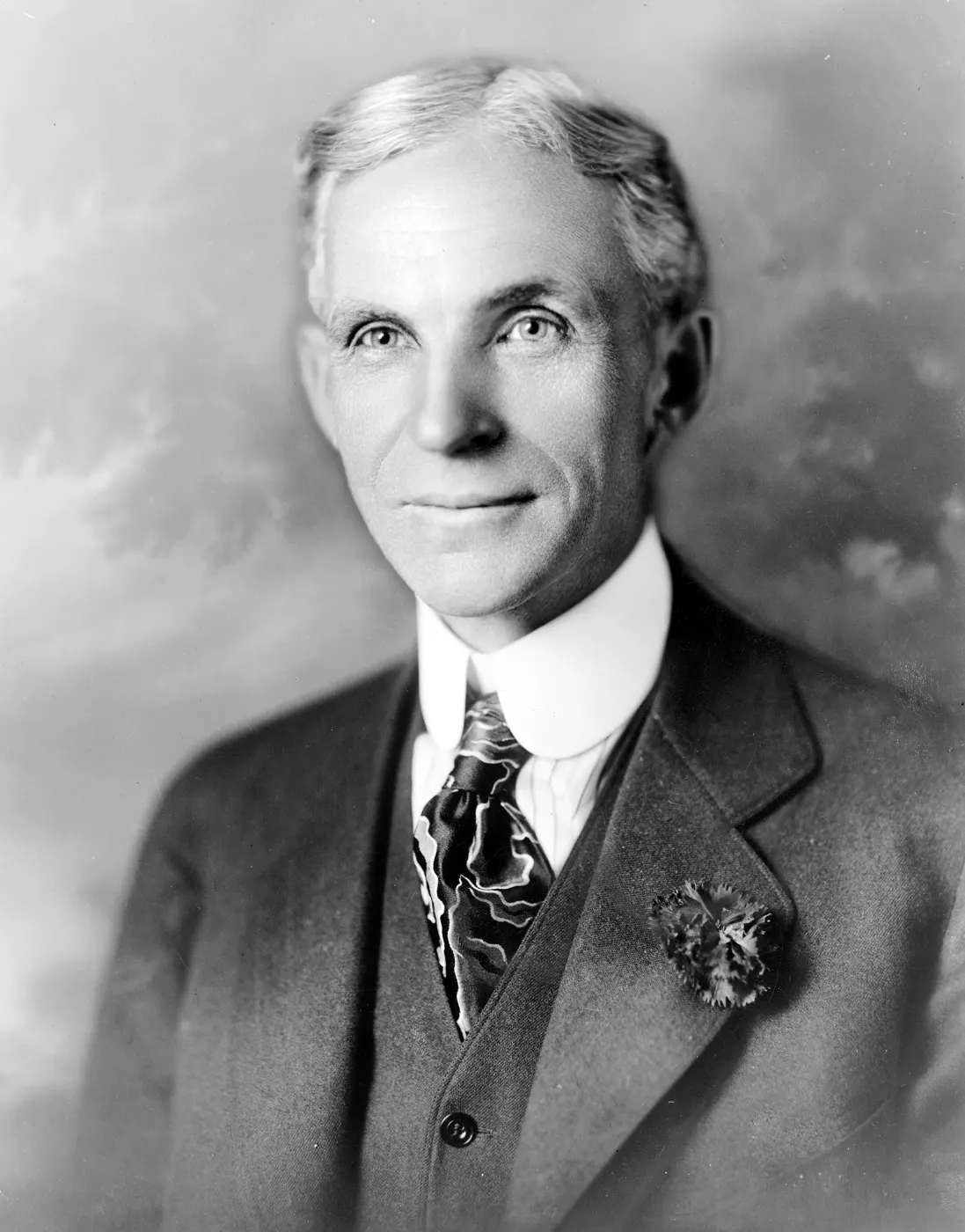 Ford in a three-piece suit and patterned tie, flower on his lapel, about 1919