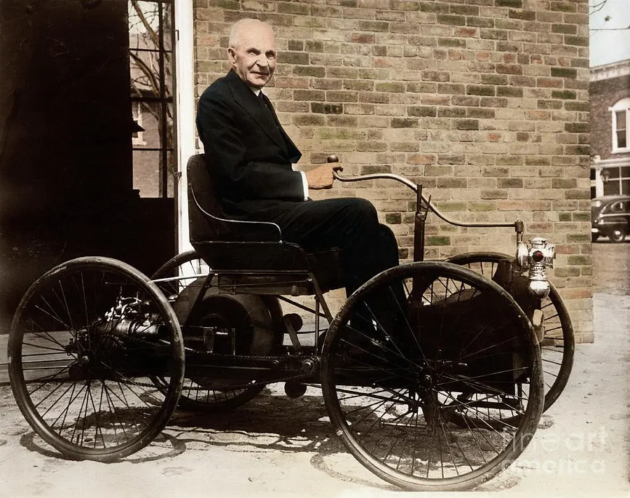 An older Henry Ford seated on his first car, the Quadricycle