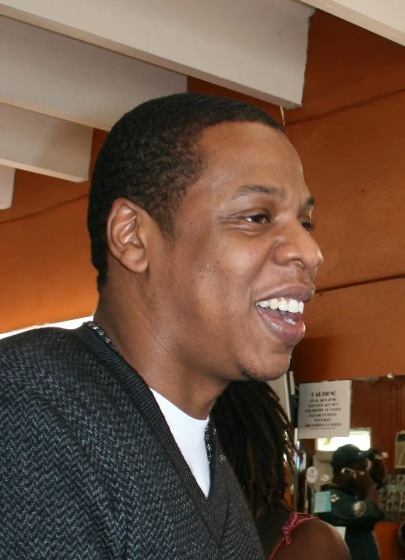 Smiling indoors in a gray sweater