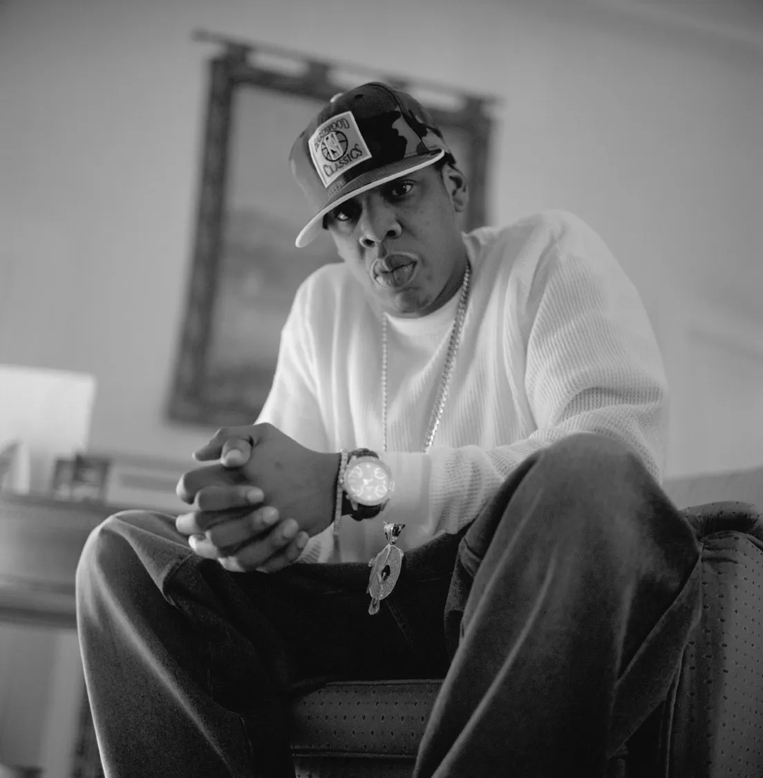 Black-and-white seated portrait in a fitted cap