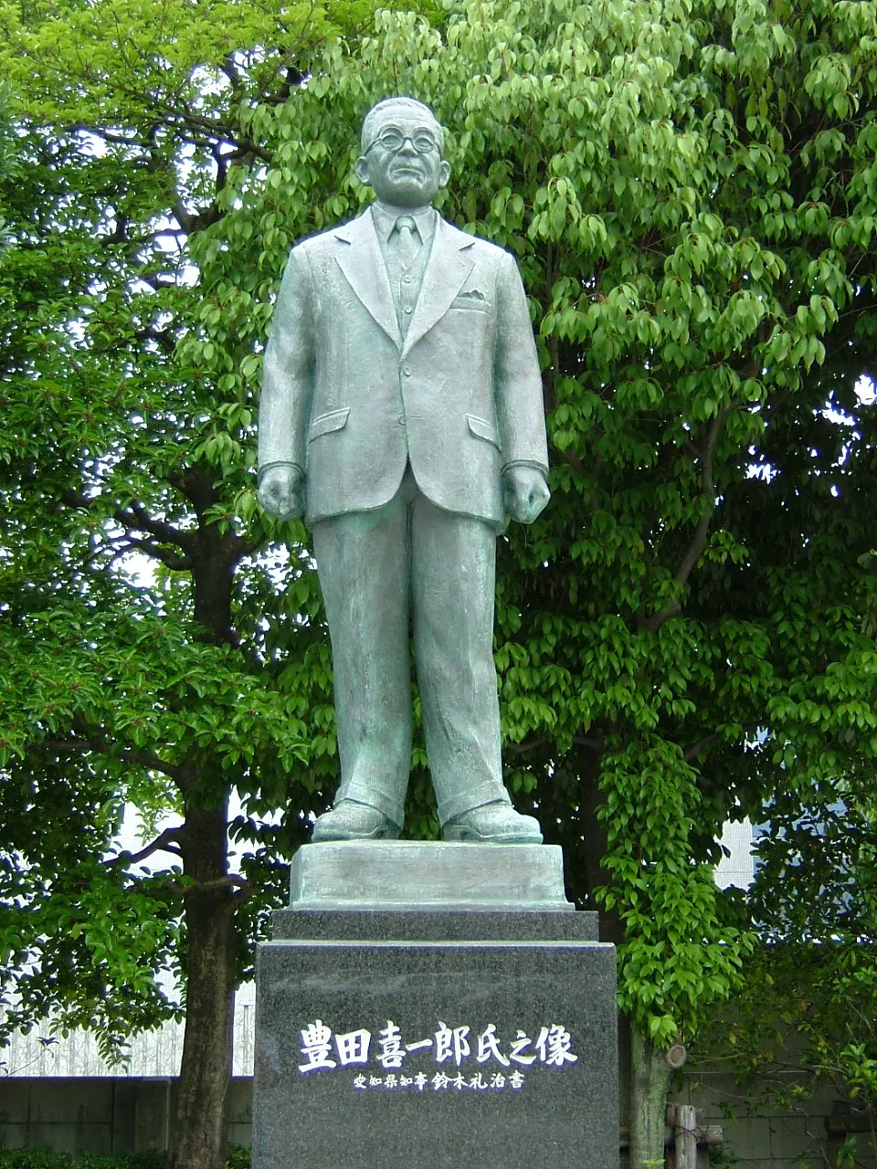 Bronze statue of Kiichiro Toyoda among trees