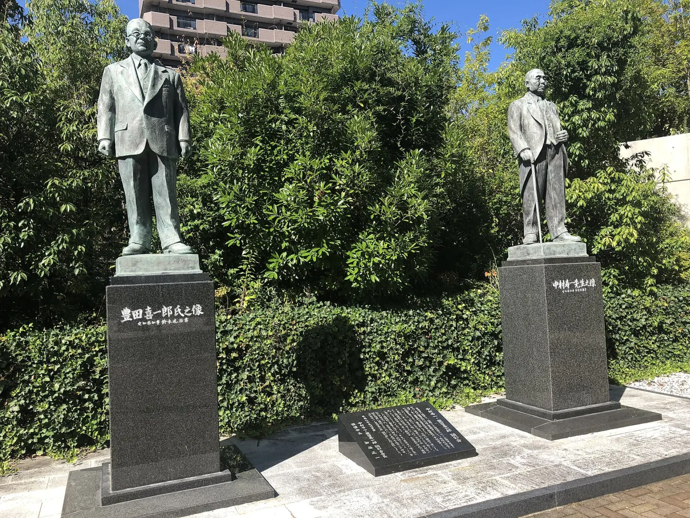 Two founder statues side by side on stone bases