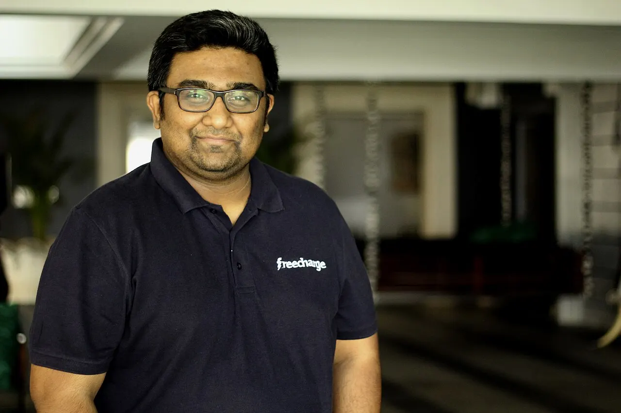Wider FreeCharge polo portrait of Shah in office lounge light