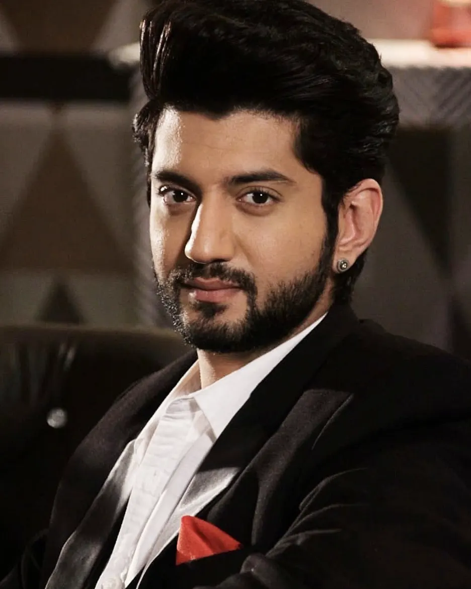 Formal portrait of Shah in dark blazer, white shirt, red pocket square