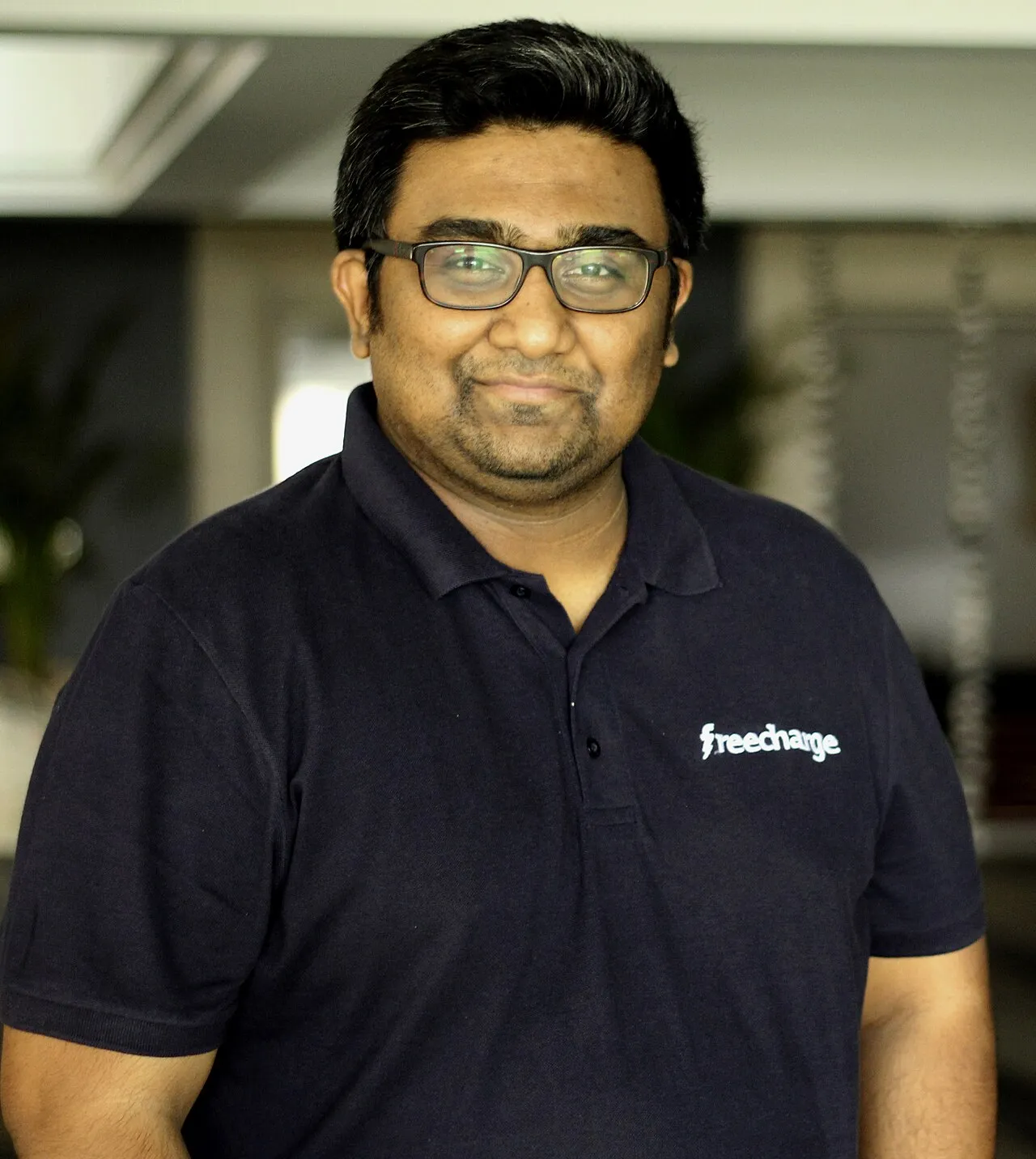 Same FreeCharge-era portrait as cover, navy polo with lightning logo