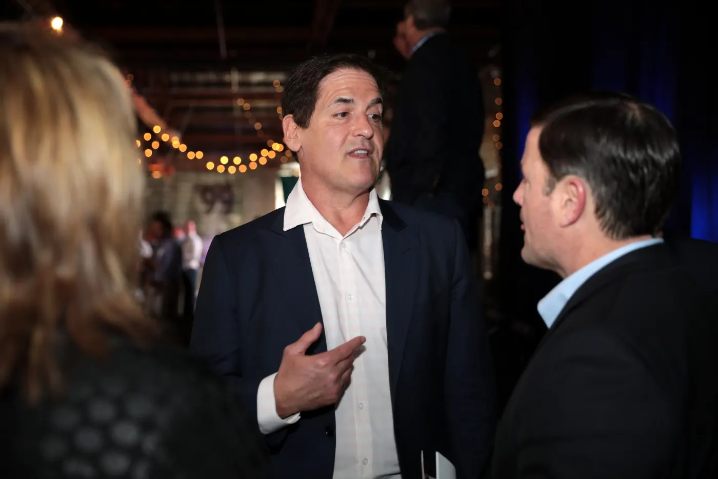 Mark Cuban talking with guests at an evening event