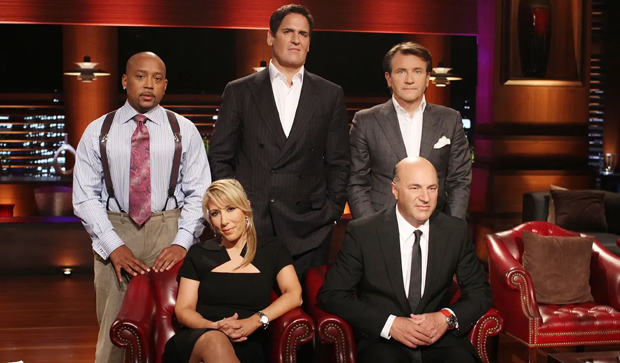 Mark Cuban with fellow Shark Tank investors posing on the show's set