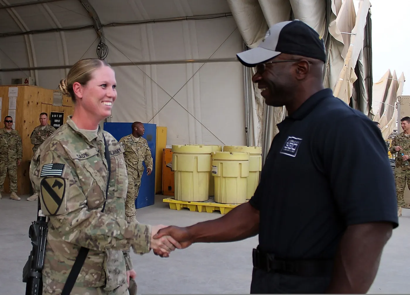 Max Mullen (often called “Mad Max”) presenting a coin to Sgt. 1st Class Misty Cady at a public event. (Wikimedia Commons, License: see Commons page, credit: creator)