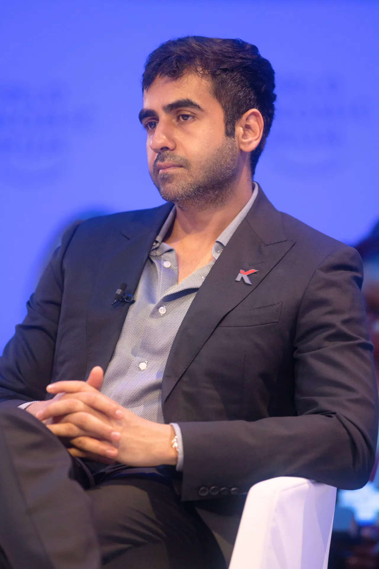 Stage portrait of Nithin with Zerodha K lapel pin and mic