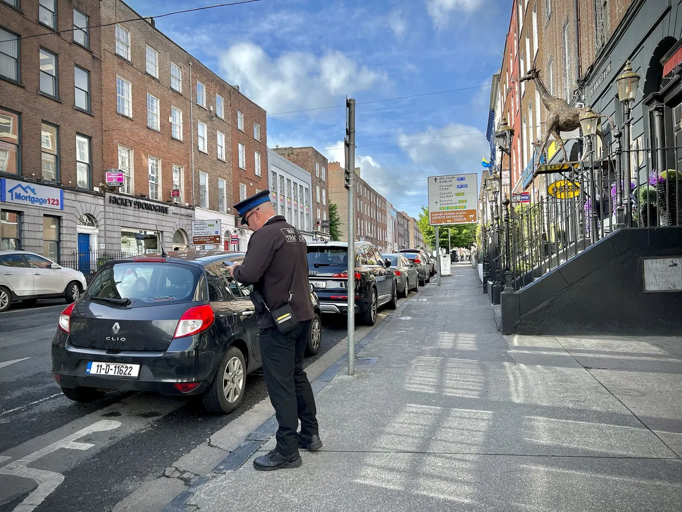 Limerick street with Irish traffic warden and bilingual signs