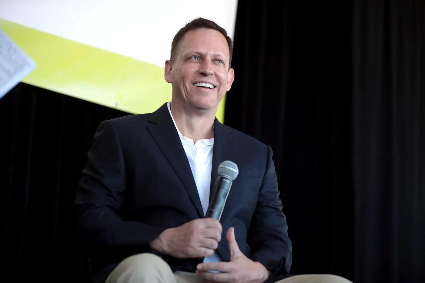 Peter Thiel smiling with microphone on stage