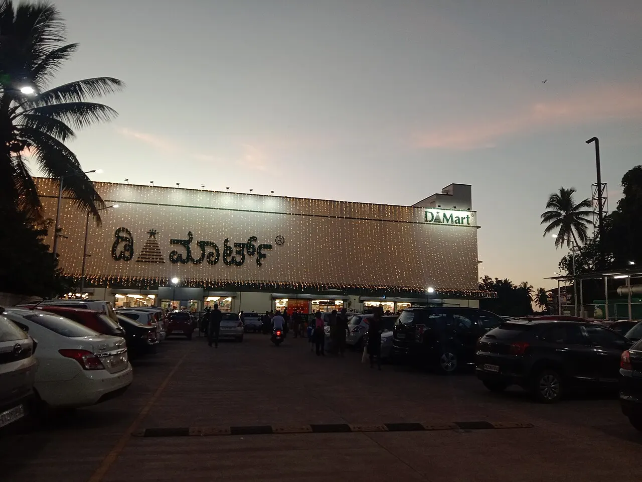 Festive dusk exterior of a DMart store with string lights