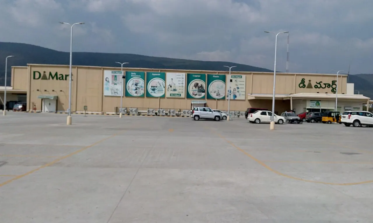 Long DMart facade with Telugu signage and hill backdrop