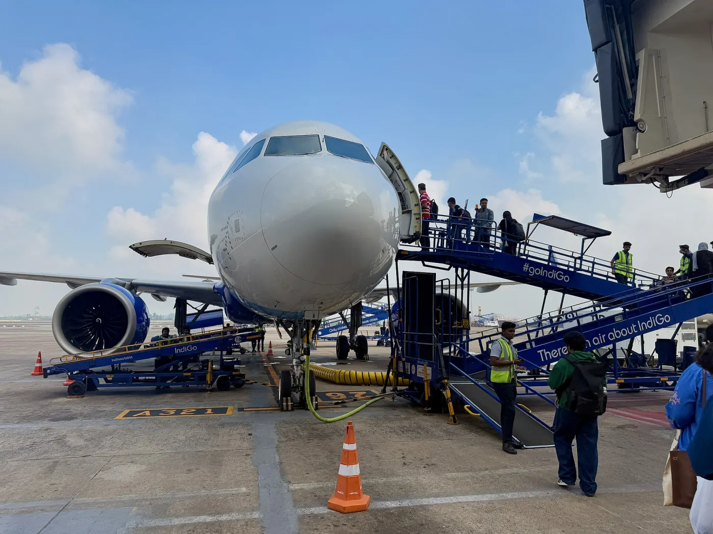 Passengers boarding an IndiGo A321 via blue stairs