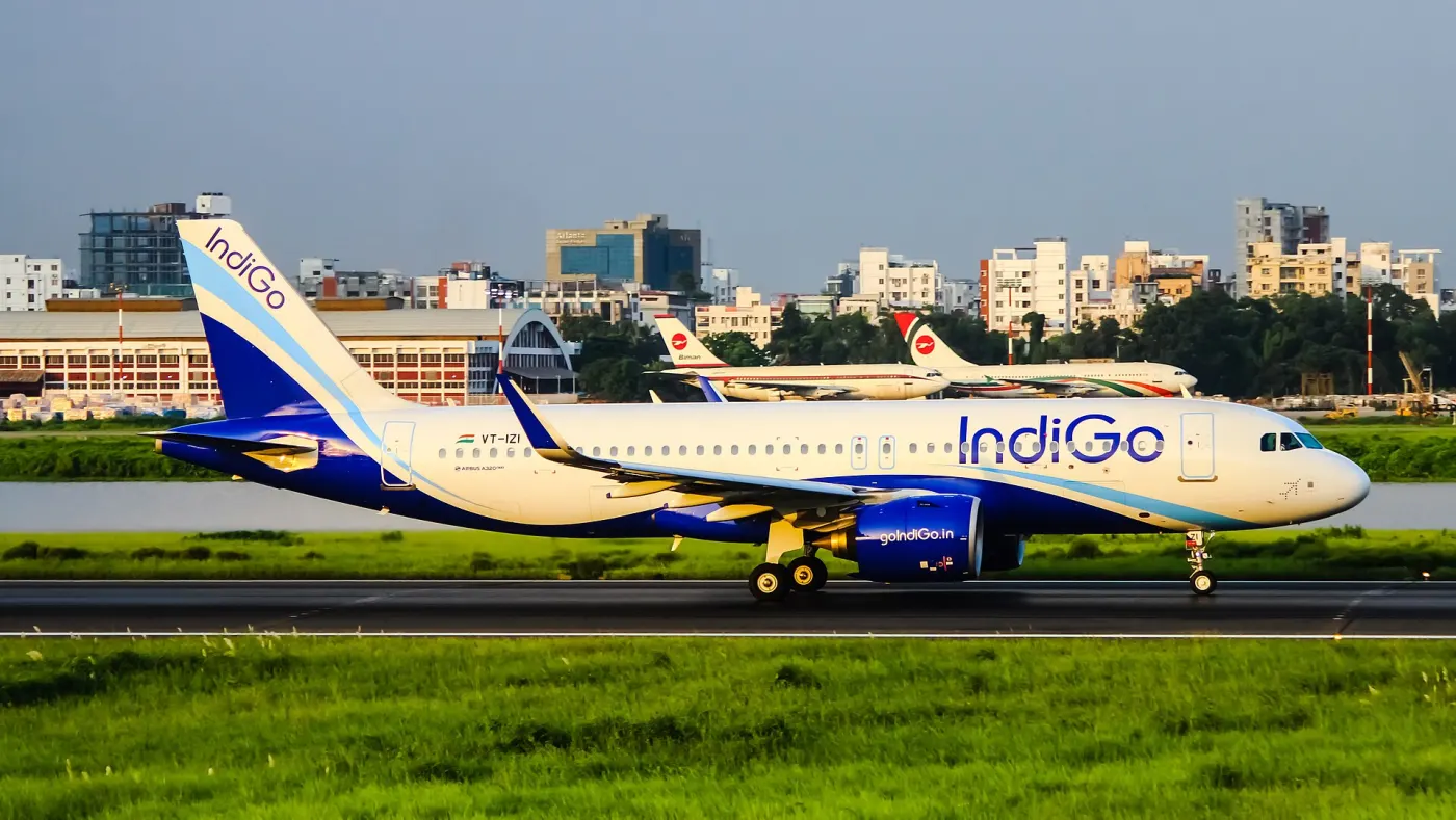 IndiGo A320neo VT-IZI on runway with city beyond