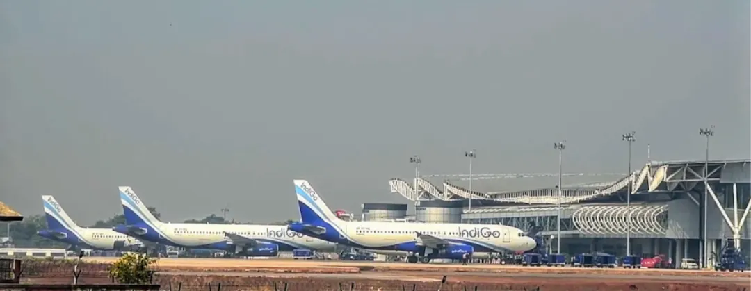 Multiple IndiGo jets at a terminal under haze