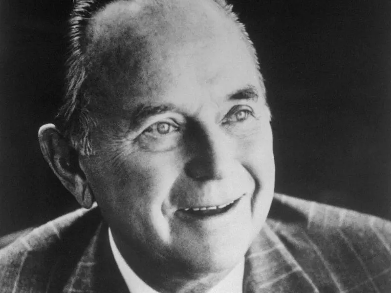 Smiling black-and-white portrait of Ray Kroc in a patterned jacket