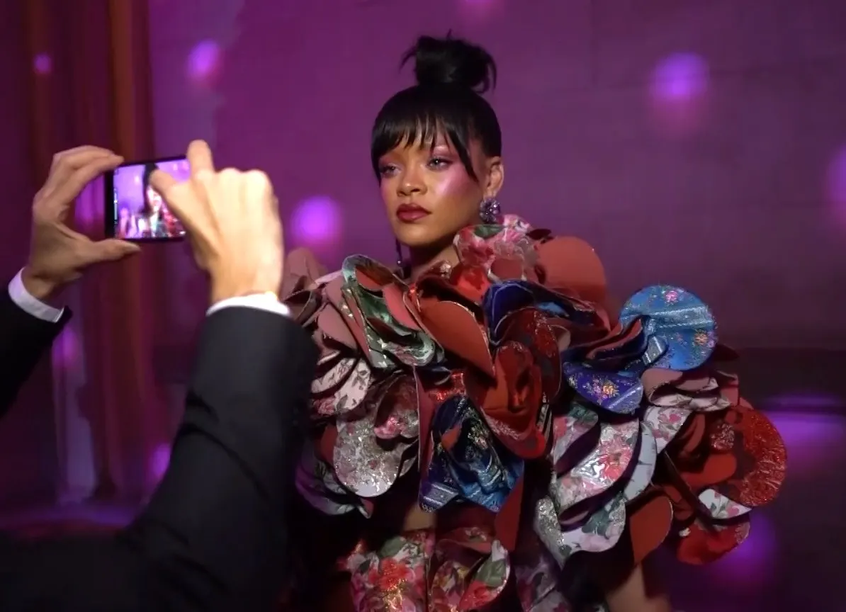 Floral ruffled gown, guests filming with phones