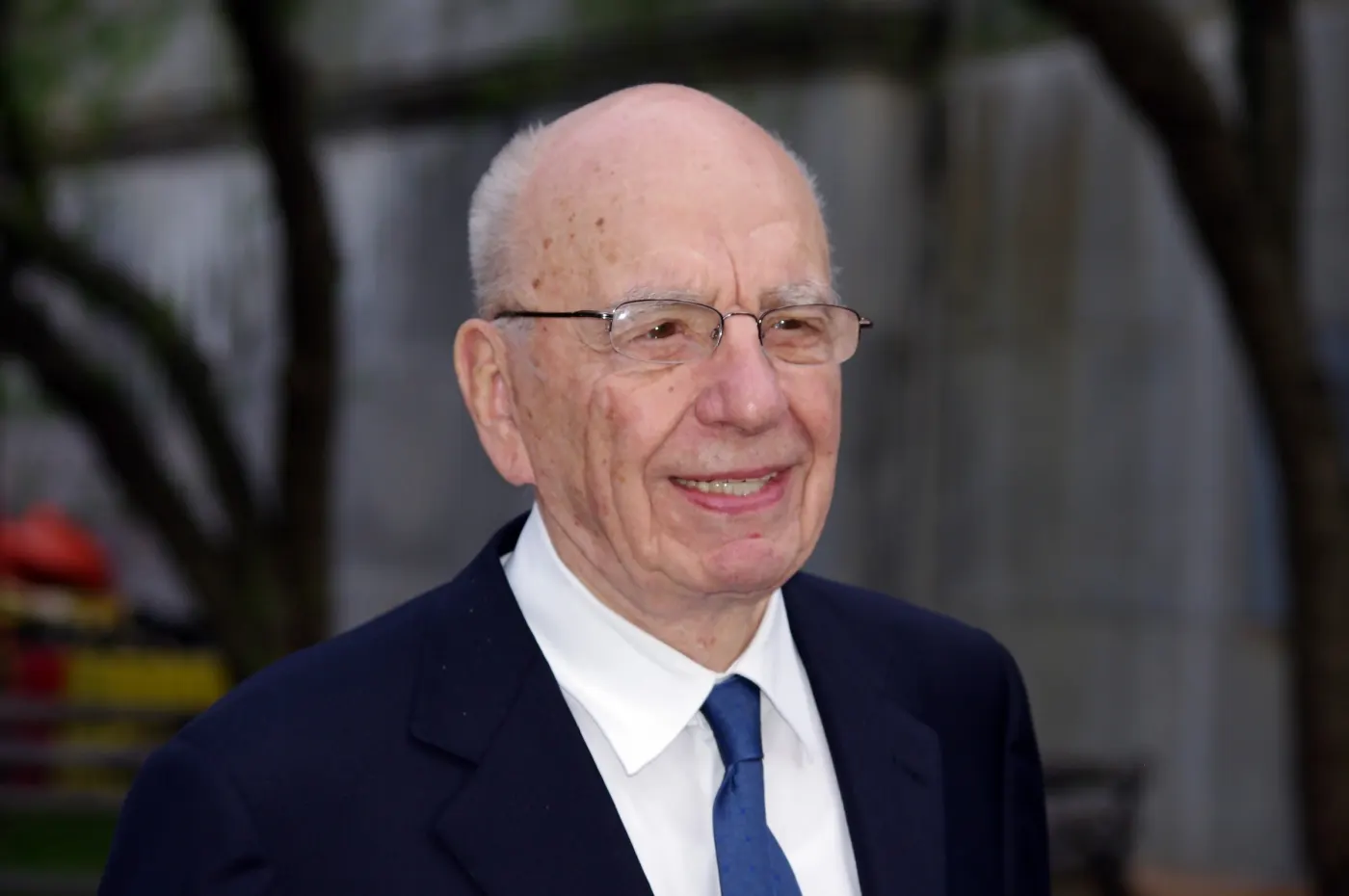 Outdoor portrait, glasses, navy suit, smiling
