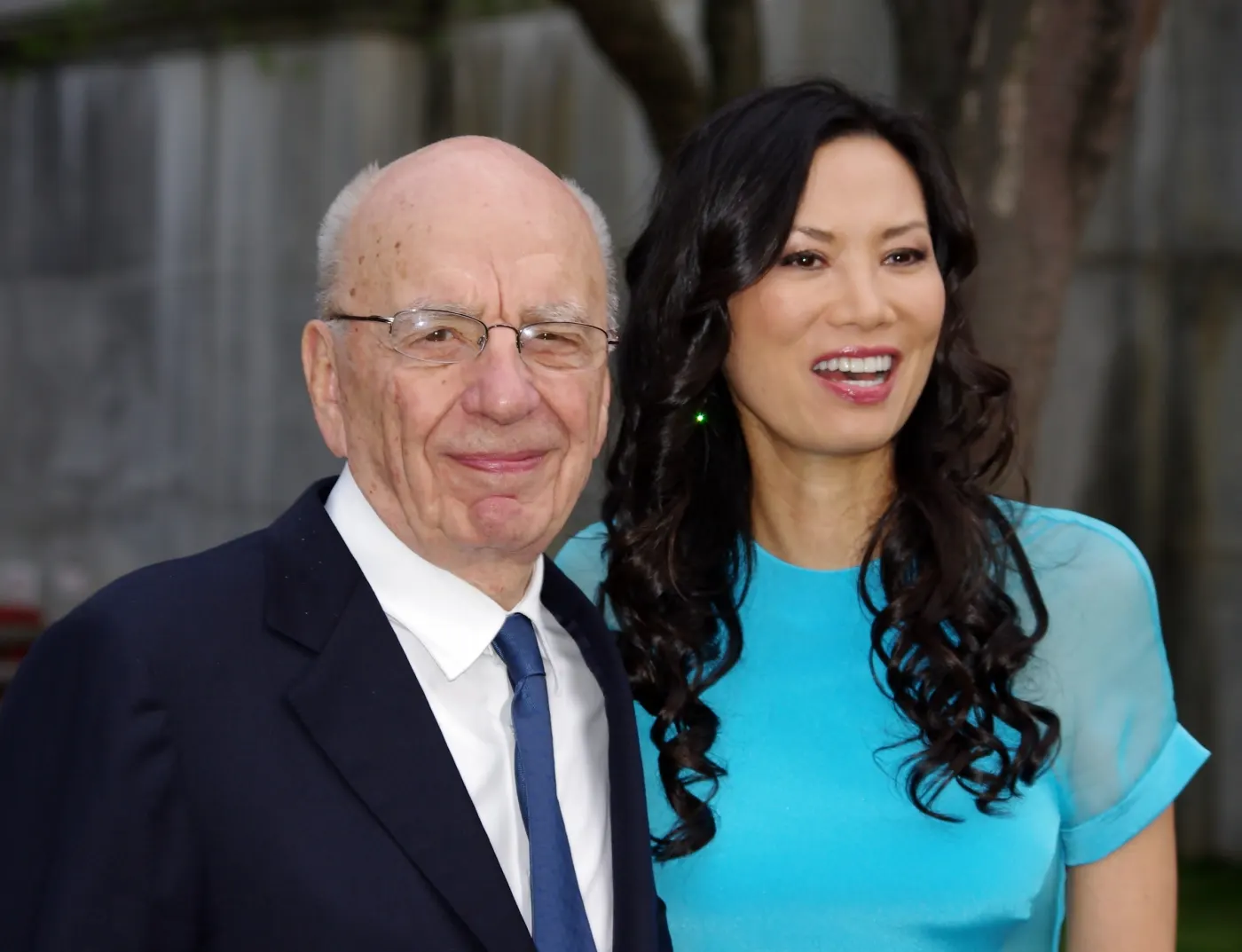Murdoch in suit beside Wendi Deng in teal dress, outdoor event