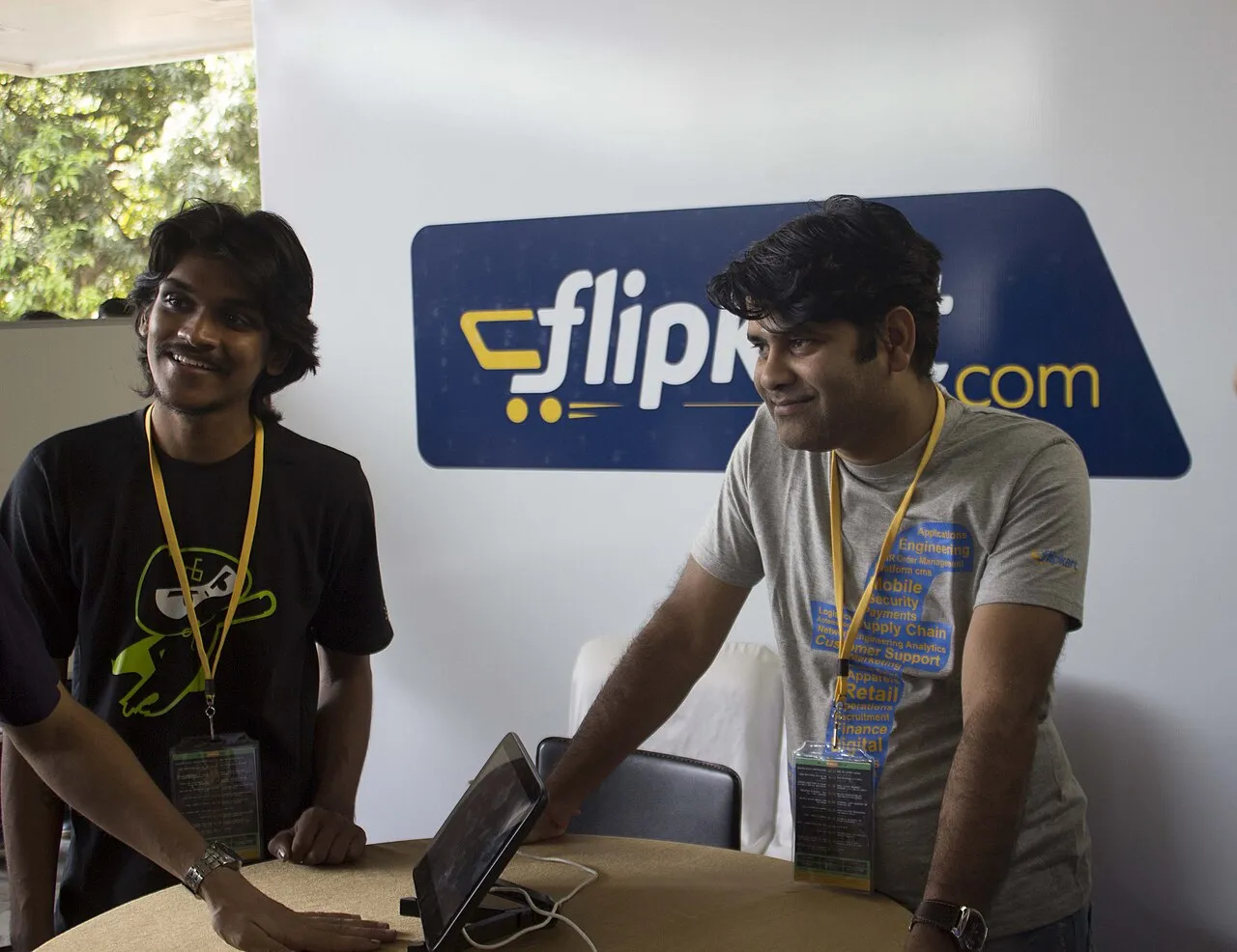 Young Sachin Bansal and Binny Bansal at an early Flipkart booth with yellow lanyards