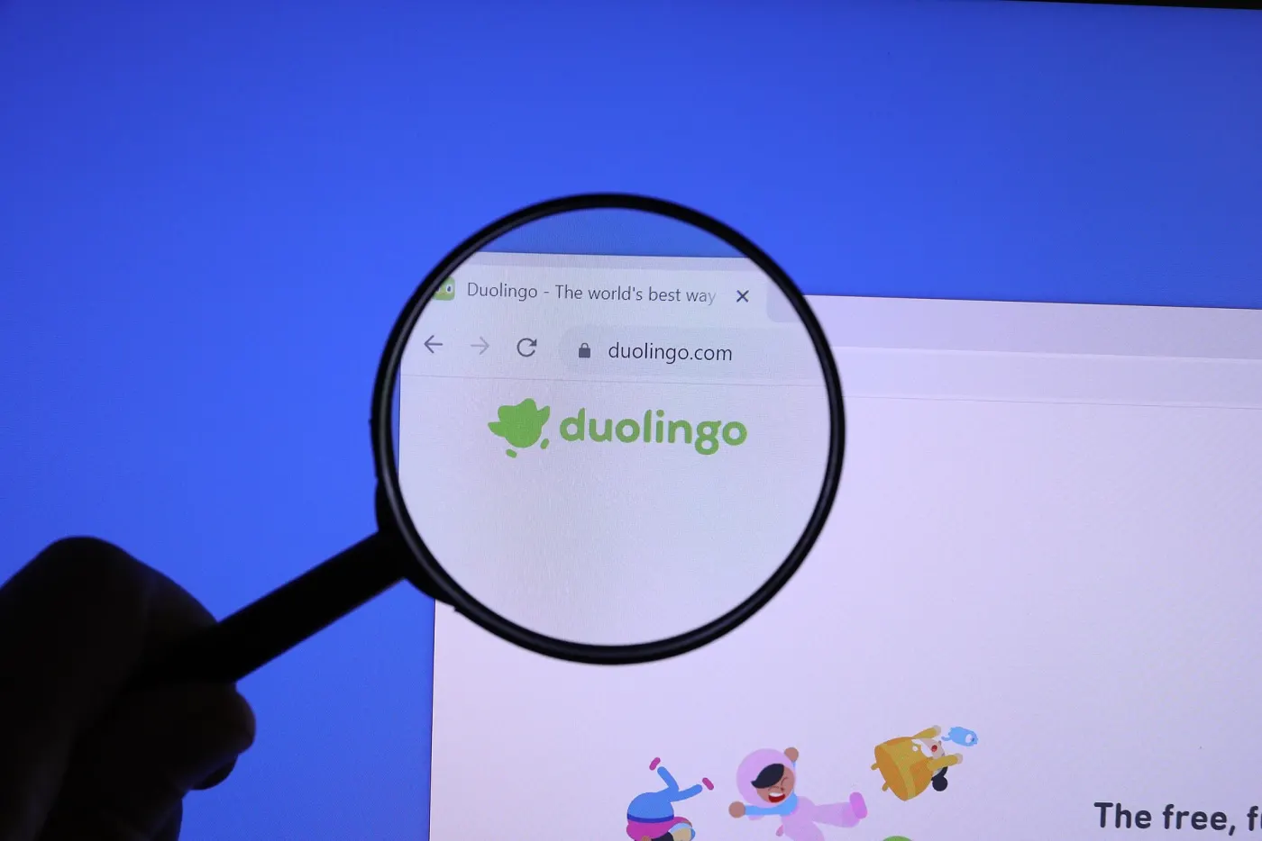 A magnifying glass over the Duolingo logo on the company's website