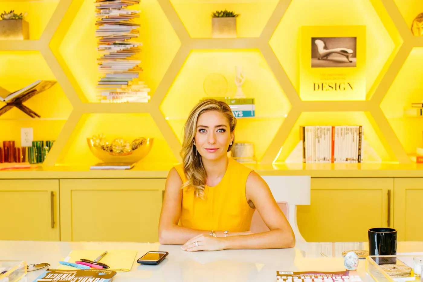 At a desk inside a bright yellow honeycomb-shelf office