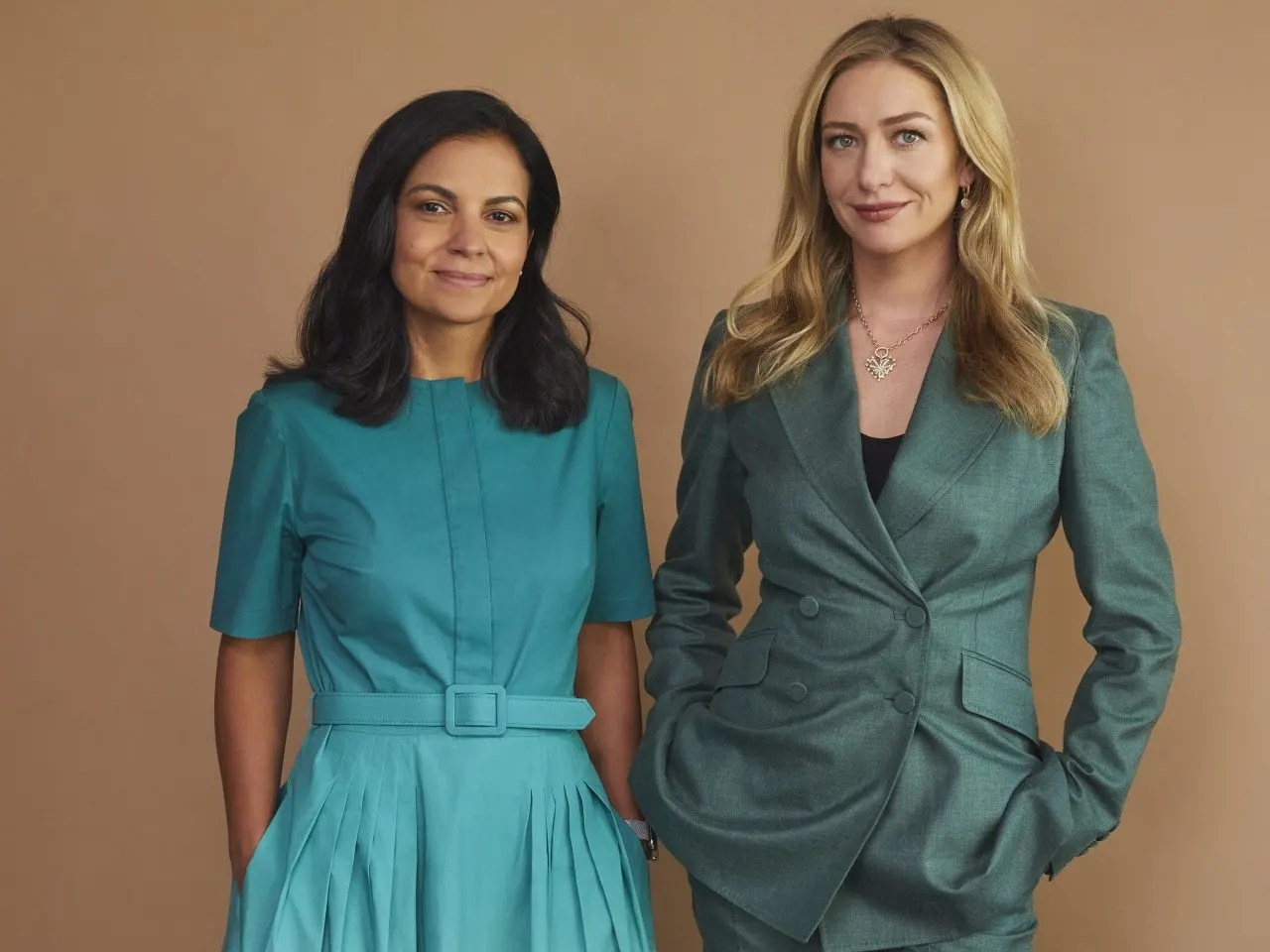 Standing beside another executive in a green suit